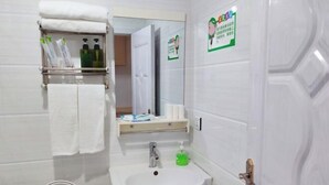 A bathroom with a toilet, sink, towel rack, and a mirror. - Apple Apartment (Yanji)