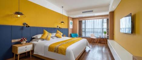 Una habitación de hotel con una cama grande, una mesita de noche y un televisor en la pared.