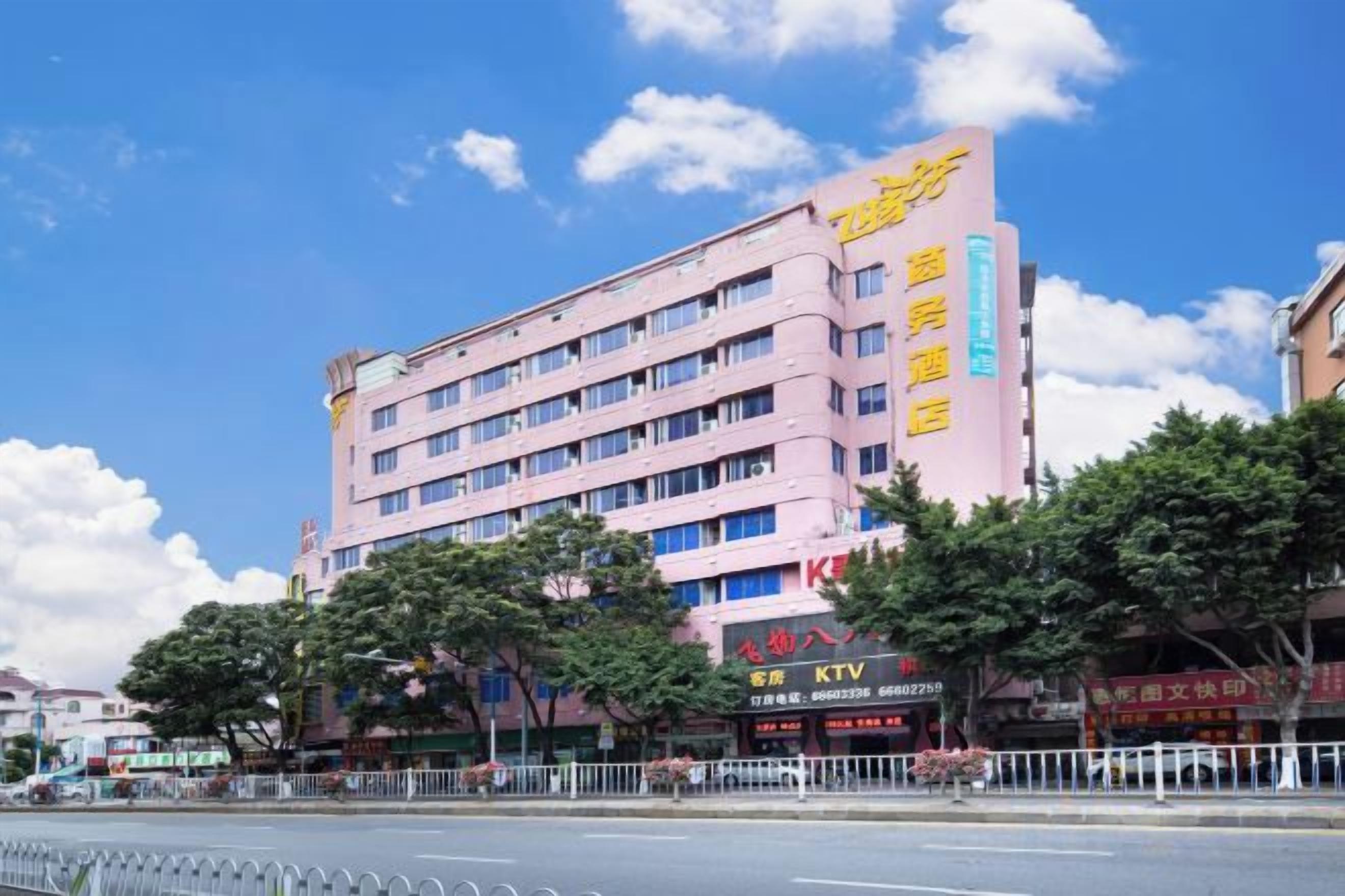 Um hotel rosa de vários andares, com uma placa visível para 'Hotel International'.