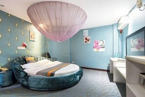 A bedroom with a round bed, a vanity, and a ceiling light fixture. - Feiyang 88 Hotel (Guangzhou Panyu Plaza) (Guangzhou)