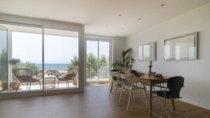 A spacious dining area with a large table and chairs, a view of the sea through large windows, and a balcony with outdoor seating. - Apt. 1st line of the sea, spectacular views 6 pax, wifi and air conditioning. Vivalidays Apartour. (Calella)