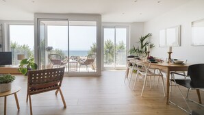 A spacious dining area with a view of the sea, a wooden bench, and a dining table set with chairs. - Apt. 1st line of the sea, spectacular views 6 pax, wifi and air conditioning. Vivalidays Apartour. (Calella)