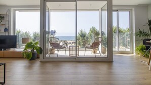 A modern living room with a sliding glass door leading to a balcony with a view of the sea. - Apt. 1st line of the sea, spectacular views 6 pax, wifi and air conditioning. Vivalidays Apartour. (Calella)