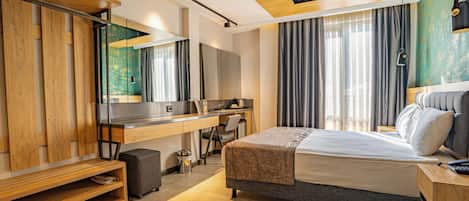 A modern hotel room with a large bed, a desk, and a wardrobe.