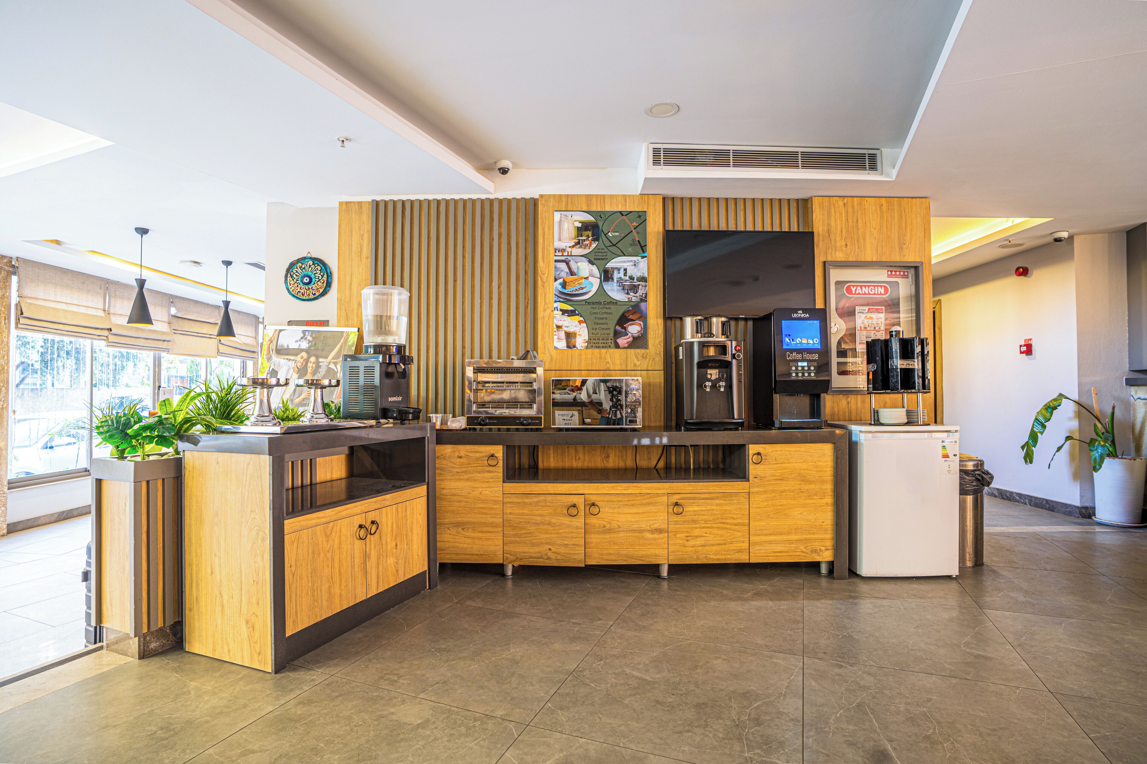 A modern coffee shop with a wooden counter, espresso machine, and a coffee machine.