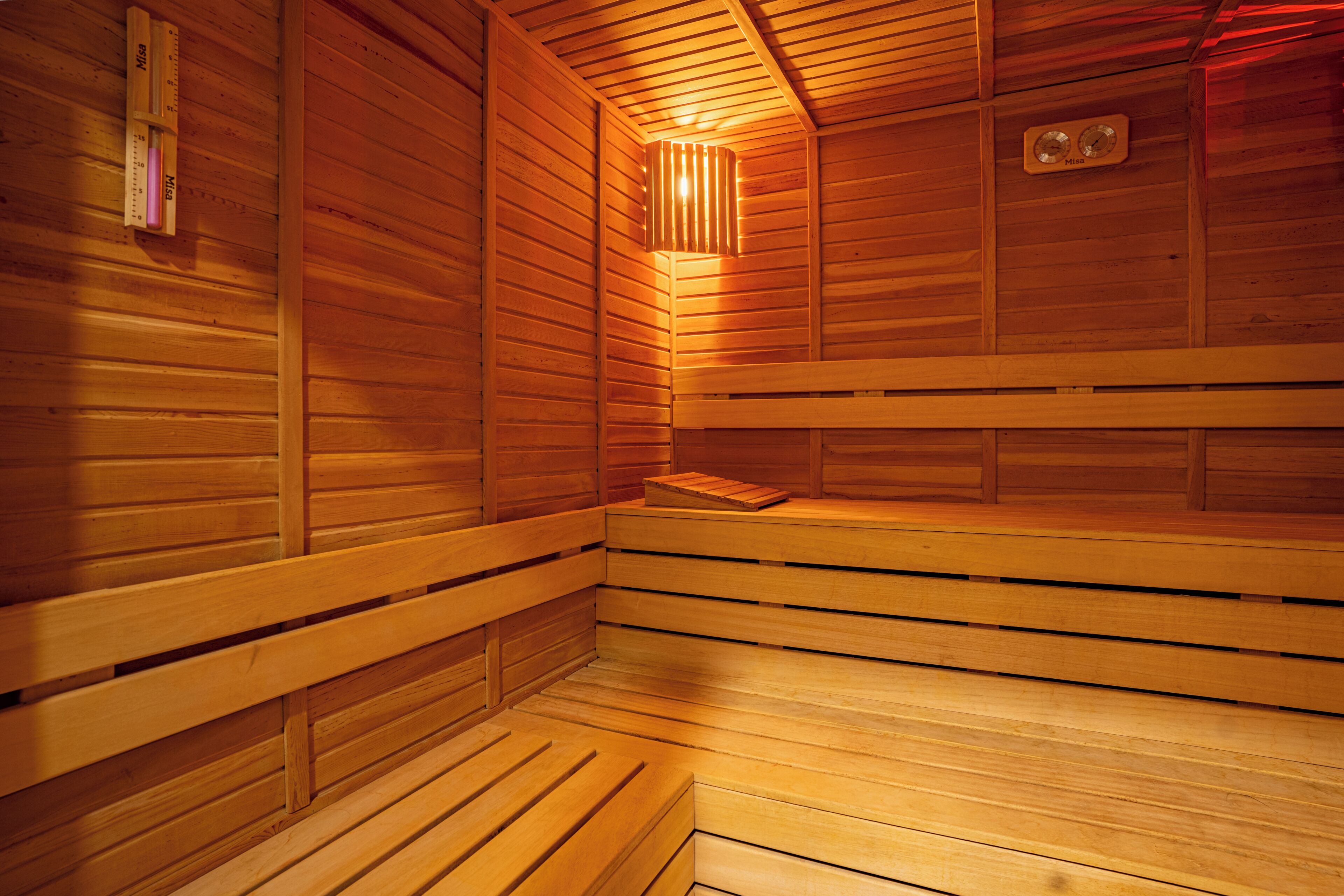 A sauna with wooden benches and a slanted ceiling.