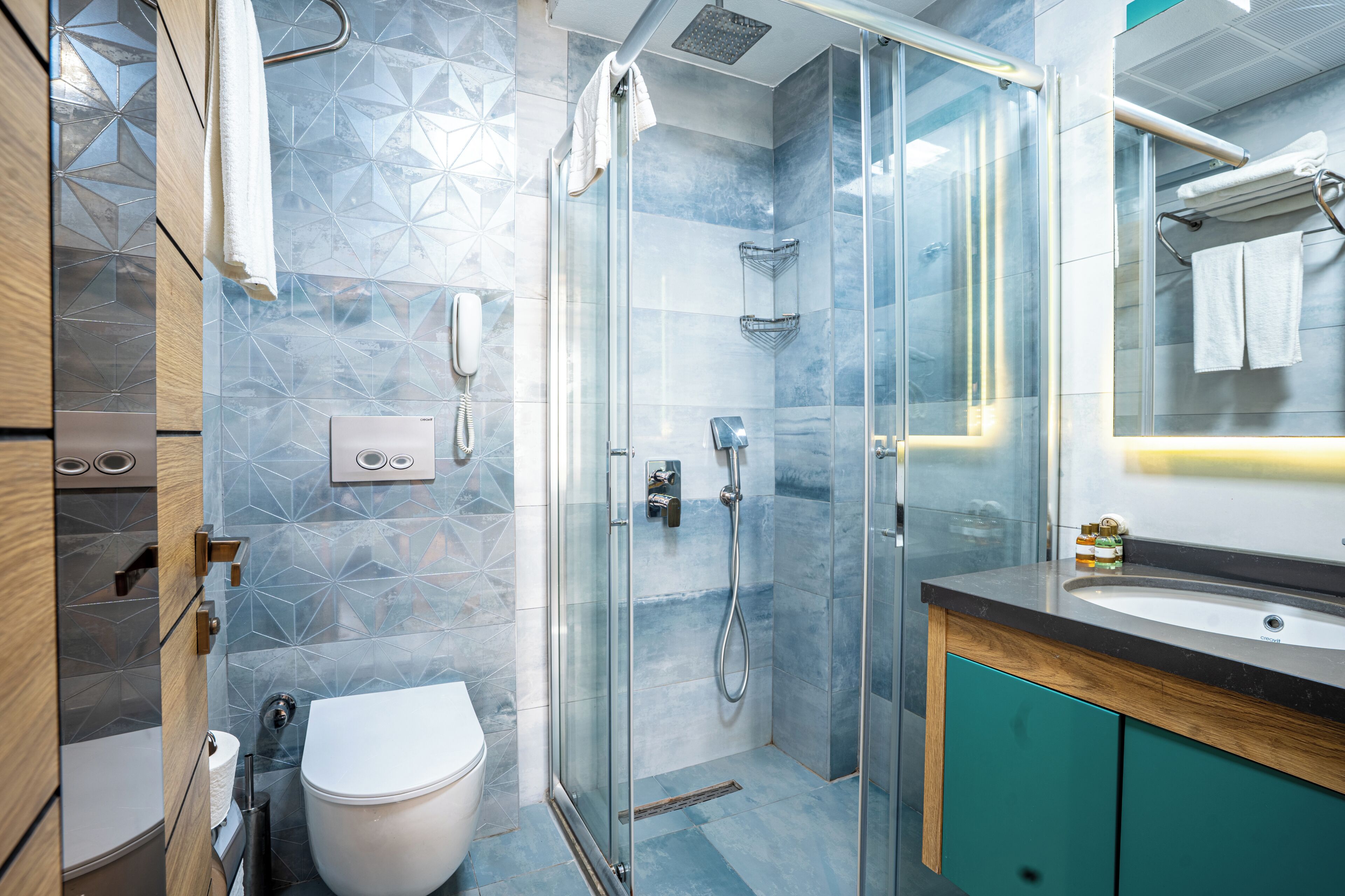 A modern bathroom with a glass shower enclosure, a toilet, and a vanity with a sink.