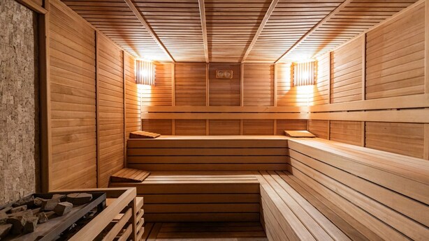 Uma sauna com bancos de madeira e teto inclinado.
