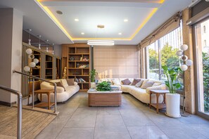 A modern living room with a sofa set, a coffee table, and a bookshelf. - Peramis Hotel & Spa (Antalya)