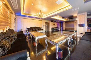 A luxurious hotel lobby with a grand chandelier, plush seating, and a reflective marble coffee table.