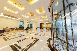 A spacious lobby with a high ceiling, large windows, and a central column. - Jinqiu Holiday Hotel (Shanghang)