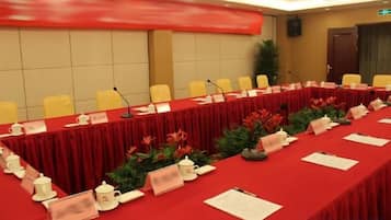 A conference room with a long table, chairs, nameplates, and microphones.