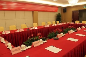 A conference room with a long table, chairs, nameplates, and microphones. - Jinqiu Holiday Hotel (Shanghang)