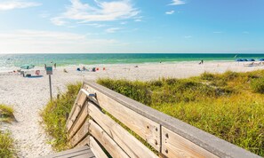 Relax on the beach with comfortable chairs and umbrellas, steps from the ocean.