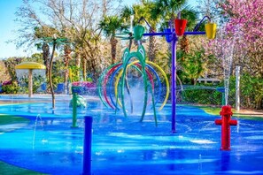 A water park with a colorful water play area, including a water slide and various water features.