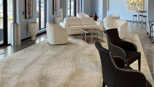 A spacious lobby with modern furniture, large windows, and industrial ceiling design. - Washburn Hotel Suites (Topeka)