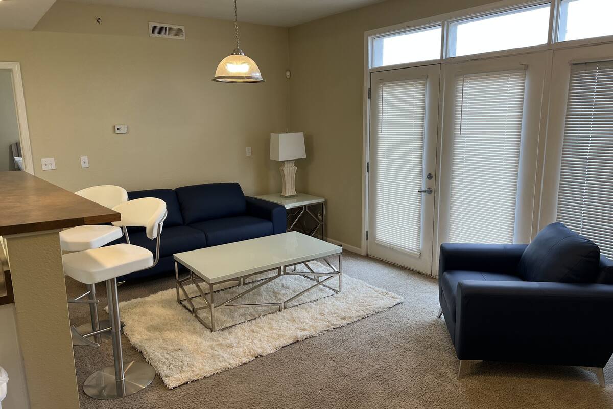 A living room with a sofa, a coffee table, and a lamp.