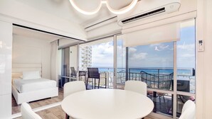 Une chambre d’hôtel moderne avec un balcon, une table ronde et un lit.