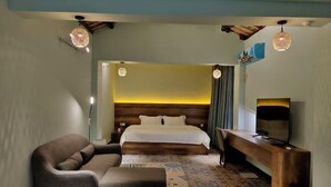 Una habitación de hotel con cama, escritorio, silla y televisión.