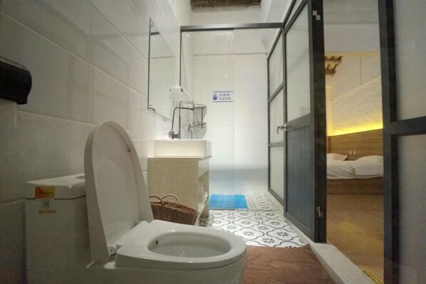 Een kleine badkamer met toilet, wastafel en douche.