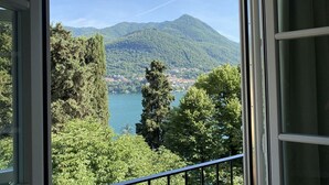 Vista dalla finestra su un lago e montagne.