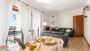Een eethoek met een houten tafel, gedekt voor het ontbijt, inclusief fruit en drankjes.