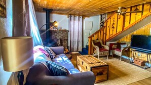Un intérieur chaleureux avec des éléments en bois, un canapé, un meuble rouge et un téléviseur.
