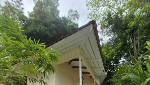A house with a covered porch and a staircase leading to a deck. - Grand Park Manuel Antonio (Quepos)