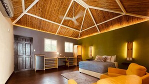 A spacious bedroom with a large bed, a desk, and a chair. - Grand Park Manuel Antonio (Quepos)