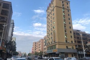 Un edificio de varios pisos con fachada plana, varios balcones y una entrada a nivel de calle.