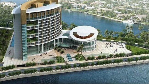 Un hotel moderno con fachada curva, un patio central circular y vista al agua.