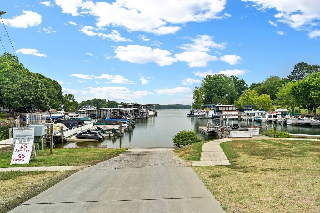 A marina with boats docked, a ramp fee sign, and a clear sky.