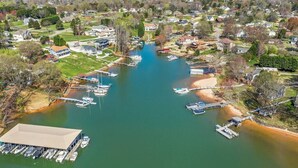 An aerial view of a marina with boats docked, surrounded by residential houses and greenery.