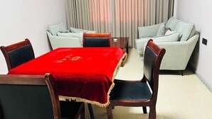A room with a dining table, four chairs, a sofa, and a curtain. - Hongye Hotel (Langxi)