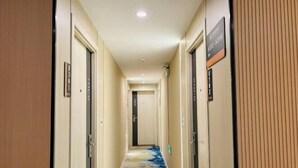 A hotel hallway with doors labeled with room numbers and a carpet with a blue and yellow pattern. - Hongye Hotel (Langxi)