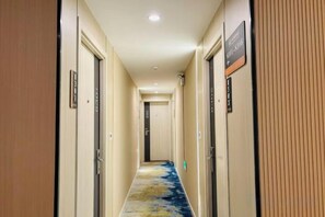 A hotel hallway with doors on both sides, a carpeted floor, and a sign indicating room availability. - Hongye Hotel (Langxi)