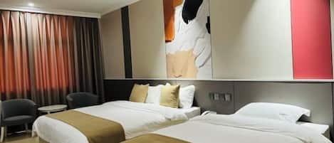 A hotel room with two beds, a desk, and a chair.