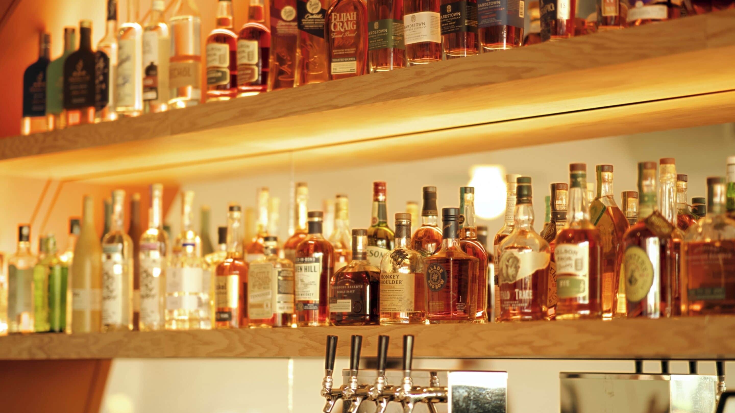 Een bar met meerdere flessen drank en een tappunt.