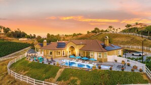 A large house with a swimming pool, solar panels, and a fenced garden. - Gaia Inn and Spa - Adults Only - Temecula Wine Country (Temecula)