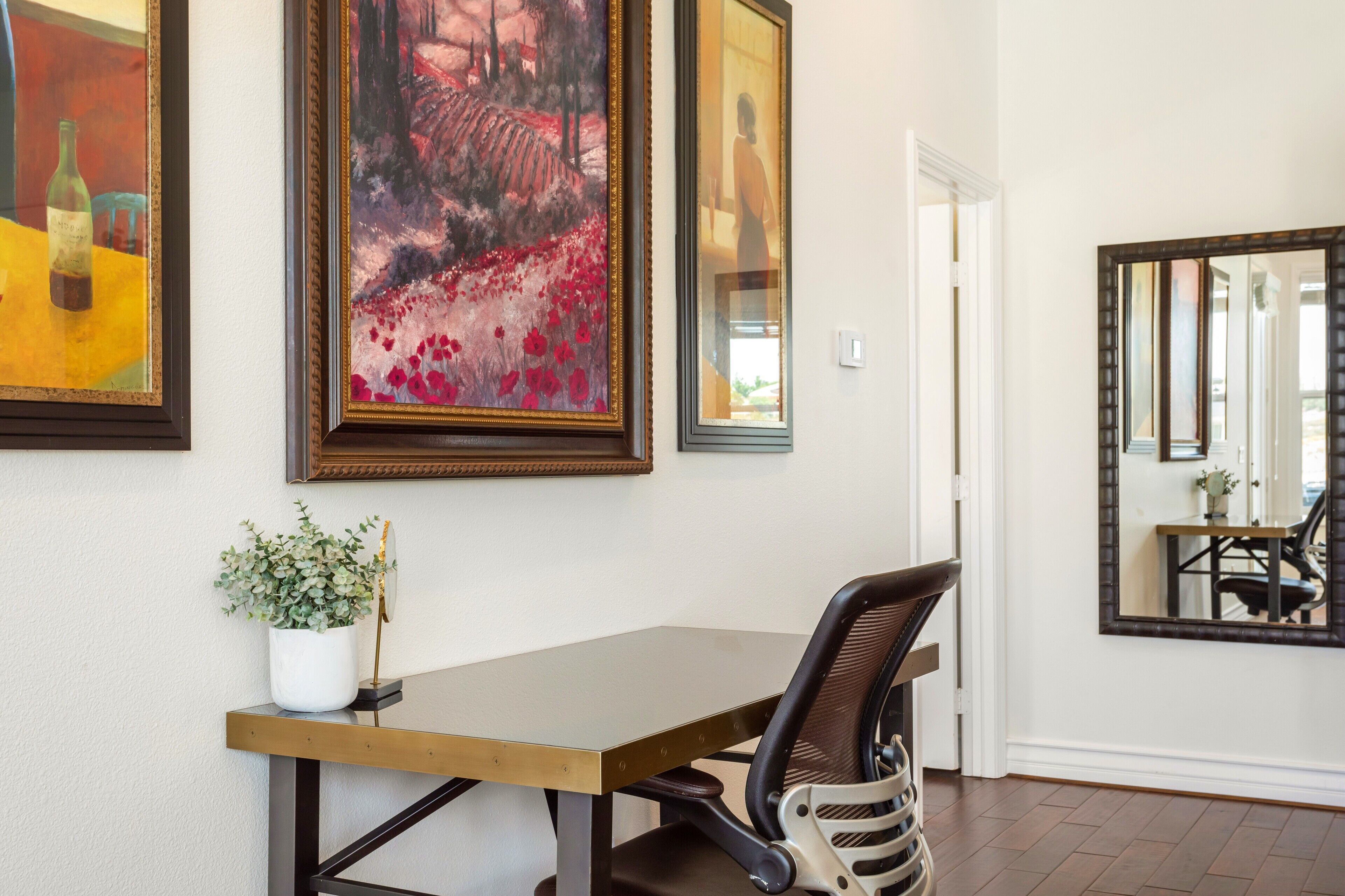 A dining area with a wooden table, a potted plant, and a chair.