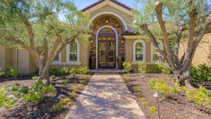 A building with a brick facade, a central arched entrance, and a pathway leading to the door. - Gaia Inn and Spa - Adults Only - Temecula Wine Country (Temecula)