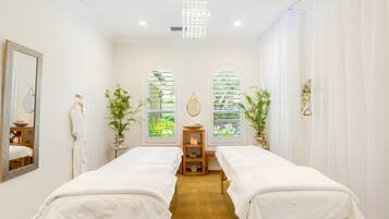 Relax in a serene space with two single beds, a large mirror, and a peaceful view of lush greenery.