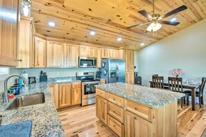 Enjoy cooking in this well-equipped kitchen with a refrigerator, microwave, oven, sink, and dining area.