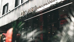 Fachada de un hotel con el nombre "GUANGGA HOTEL" en letras grandes.