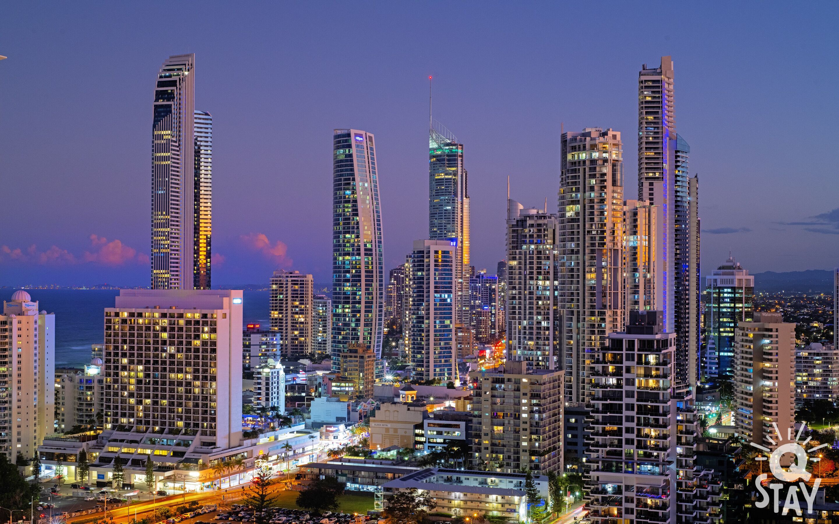 A high-rise urban skyline with modern architecture, including a prominent hotel with a dome and a large building with a unique facade.