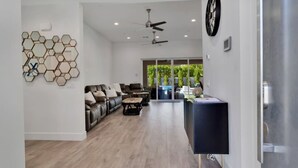 A spacious living area with a dark-colored sofa set, a coffee table, and a reception desk. - Multi month discount,luxury,entertaining +relaxing (Cathedral City)