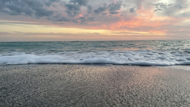 A beach with waves and a sunset. - Free Heated Saltwater Pool, Kayaks, Bikes, Tennis Rackets and Fishing Poles! (North Port)