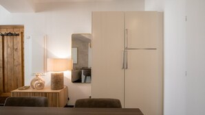 Ein modernes Zimmer mit Holztür, Spiegel, Lampe, Esstisch und großem Kleiderschrank.