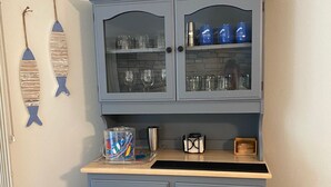 A blue cabinet with glass doors containing glasses and a coffee maker. - 2 Bedroom Coach House, Green Lake, WI (Green Lake)