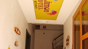 Un corridoio d'albergo con una scala, un estintore e la segnaletica dell'hotel.